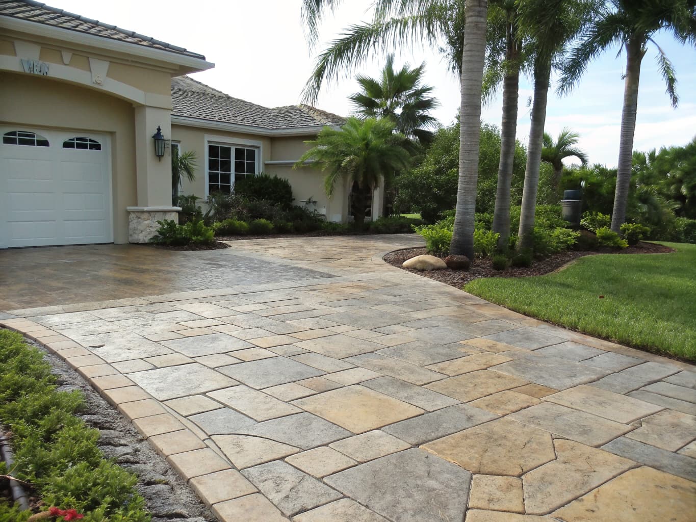 Freshly resurfaced stamped concrete driveway with tan and gray flagstone pattern at a Naples FL home