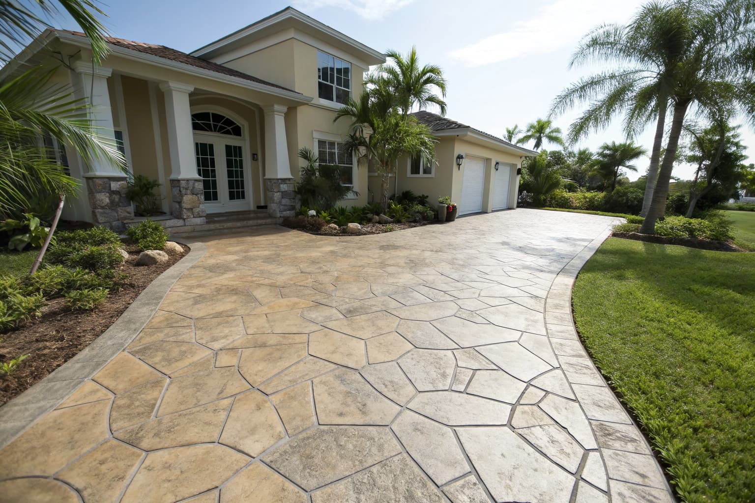 Freshly resurfaced stamped concrete driveway with tan and gray flagstone pattern at a Naples FL home