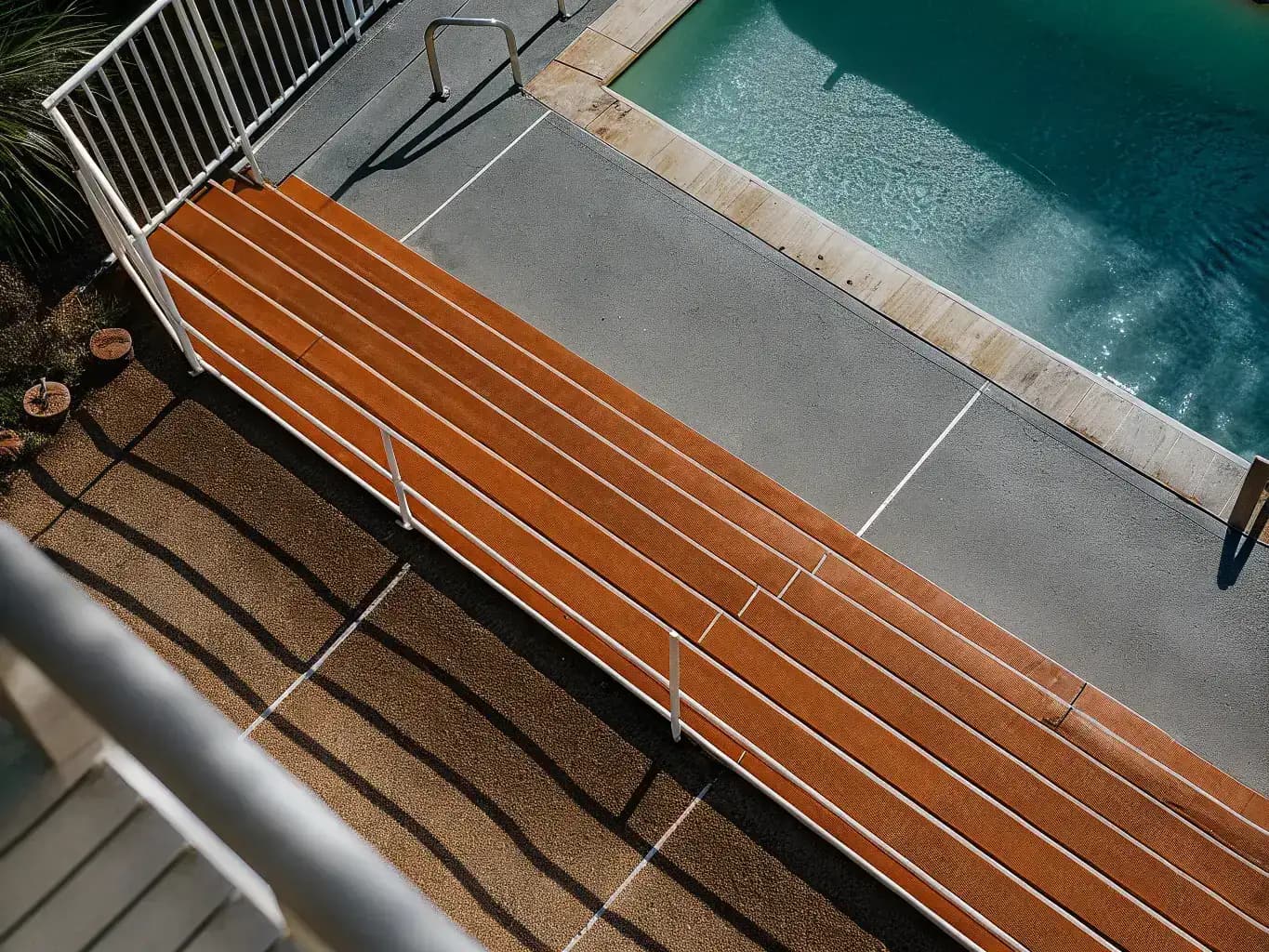 Aerial view of freshly resurfaced Florida pool deck with smooth gray overlay surrounding a sparkling blue pool