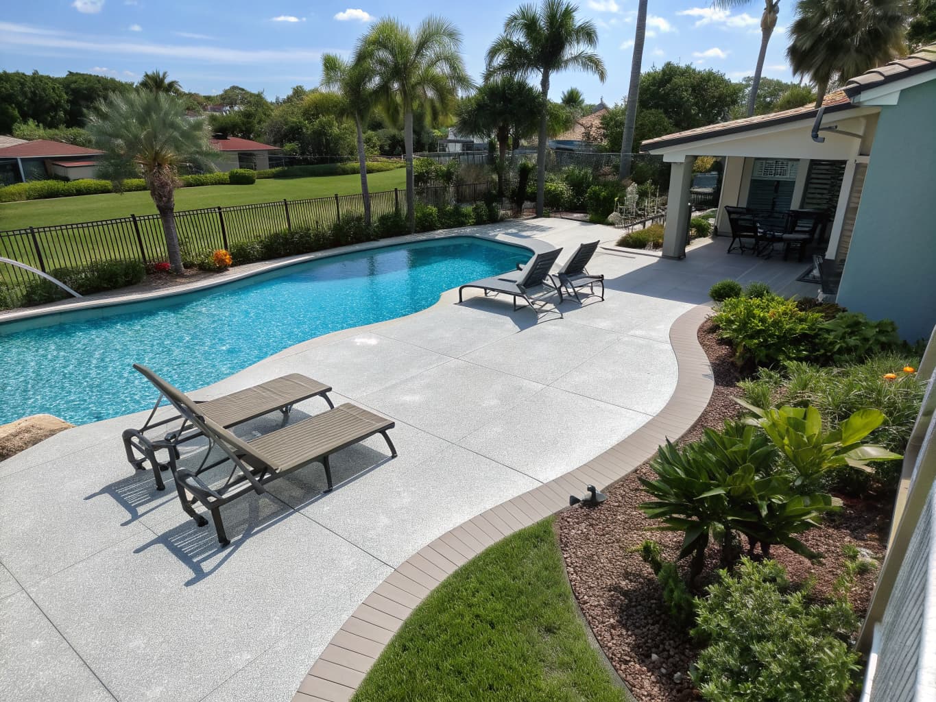 Contractor applying a spray-applied pool deck overlay coating around a Florida swimming pool