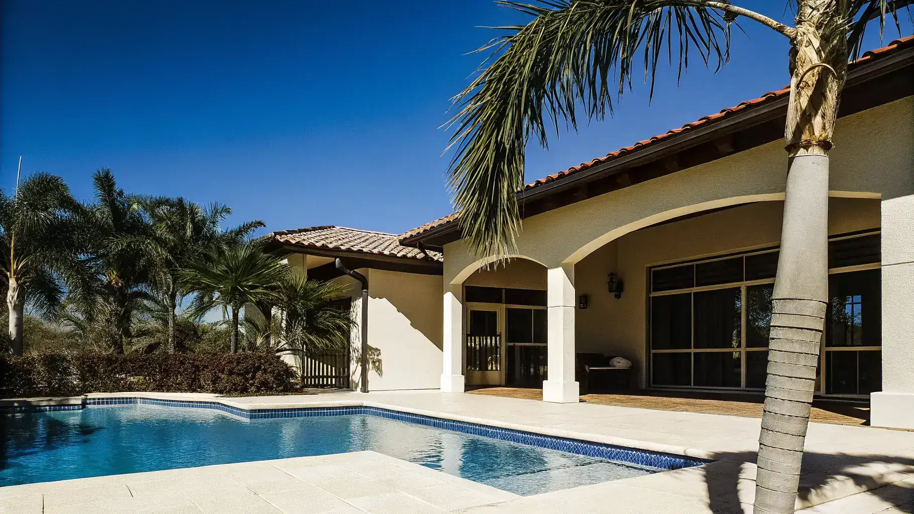 Luxury Florida backyard with freshly resurfaced pool deck surrounding a sparkling blue swimming pool