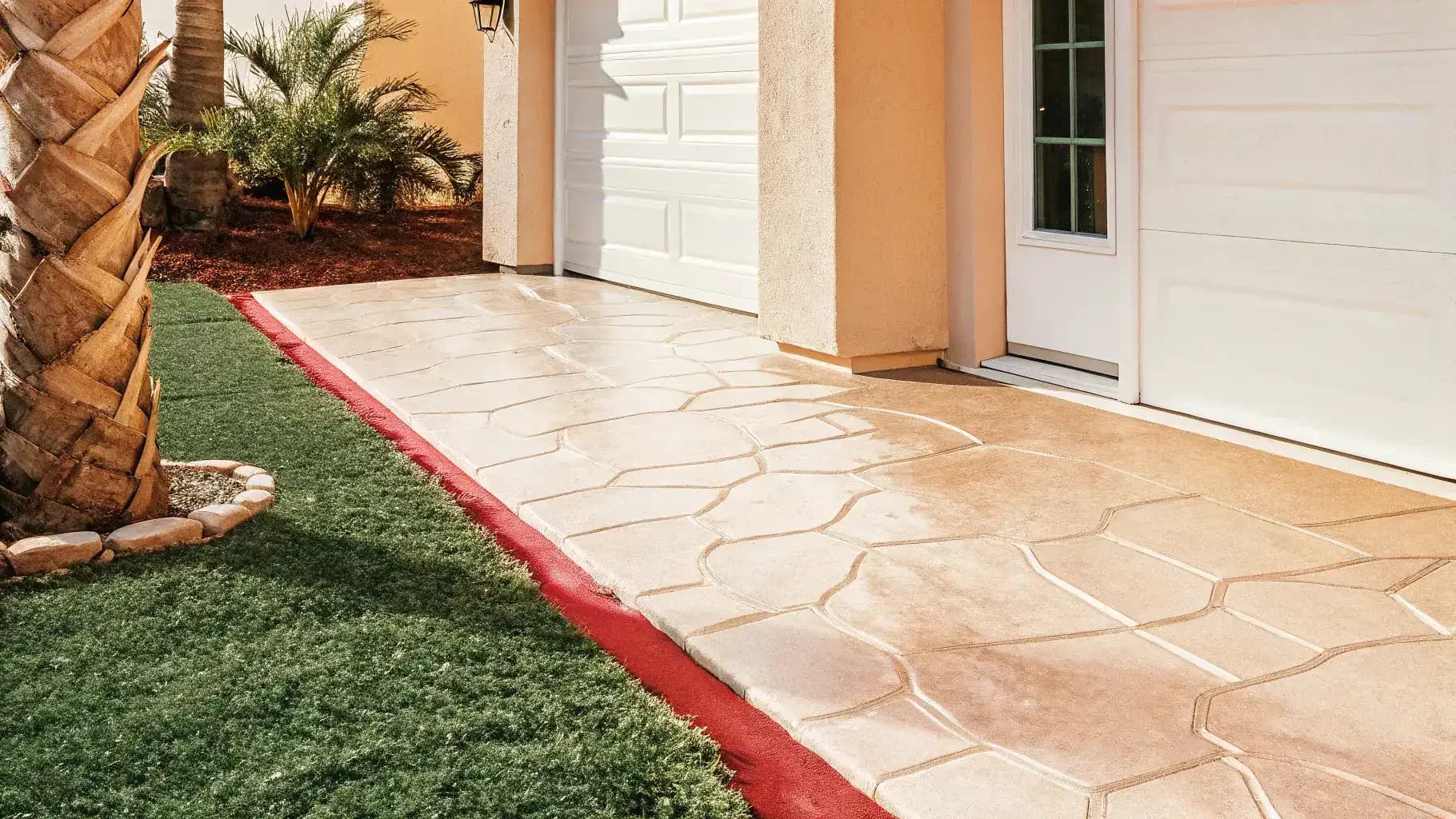 Freshly installed stamped concrete overlay with cobblestone pattern on a Florida residential driveway